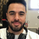 Homem branco de cabelo curto preto e barba preta